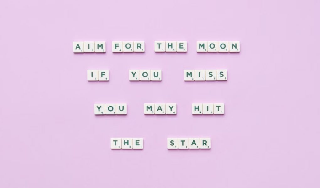 Inspirational message using Scrabble tiles on a pastel background.