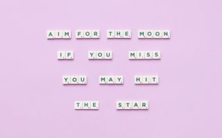 Inspirational message using Scrabble tiles on a pastel background.