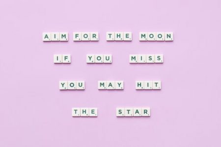 Inspirational message using Scrabble tiles on a pastel background.